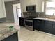 Kitchen with stainless steel appliances, dark cabinetry, and granite countertops at 434 Diamond Acres Rd, Davenport, FL 33837