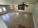 Spacious living room with tile floors, a ceiling fan, and natural light from windows at 434 Diamond Acres Rd, Davenport, FL 33837