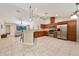Open kitchen features stainless steel appliances, wood cabinets, and a breakfast bar overlooking the living area at 510 N Leavitt Ave, Orange City, FL 32763