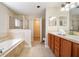 Large bathroom with a soaking tub, walk-in shower, double vanity, and access to the walk-in closet at 510 N Leavitt Ave, Orange City, FL 32763