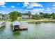 Aerial view of waterfront property featuring a boat dock and lift, grassy lawn, and lush trees at 5224 Saint Regis Pl, Belle Isle, FL 32812