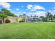 A yellow home is situated on a sprawling green lawn, featuring a screened-in pool area at 5224 Saint Regis Pl, Belle Isle, FL 32812