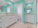 Modern bathroom featuring dual vanities, quartz countertops, and stylish blue walls at 5224 Saint Regis Pl, Belle Isle, FL 32812