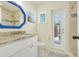 Well-lit bathroom featuring granite countertops, a blue-framed mirror, and a glass-enclosed shower at 5224 Saint Regis Pl, Belle Isle, FL 32812