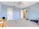 Well-lit bedroom boasts neutral carpeting, ceiling fan, and white doors leading to closet and other rooms at 5224 Saint Regis Pl, Belle Isle, FL 32812