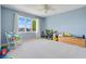 Bright bedroom features a ceiling fan, soft blue walls and a large window letting in plenty of natural light at 5224 Saint Regis Pl, Belle Isle, FL 32812