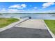 Concrete boat ramp leading into a calm lake, surrounded by green grass and clear skies at 5224 Saint Regis Pl, Belle Isle, FL 32812