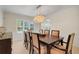 Bright dining room with a modern chandelier and large windows bringing in plenty of natural light at 5224 Saint Regis Pl, Belle Isle, FL 32812