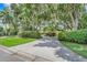 The long circular driveway with lush landscaping leads to a bright yellow two-story home at 5224 Saint Regis Pl, Belle Isle, FL 32812