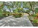 The long circular driveway leads to a bright yellow two-story home with lush landscaping at 5224 Saint Regis Pl, Belle Isle, FL 32812