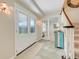 Inviting entryway with a double glass door, tile flooring, and an elegant staircase leading to the upper level at 5224 Saint Regis Pl, Belle Isle, FL 32812