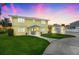 Bright yellow two-story home featuring a spacious lawn at sunset at 5224 Saint Regis Pl, Belle Isle, FL 32812