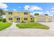 Bright yellow two-story home featuring a spacious lawn and attached two-car garage at 5224 Saint Regis Pl, Belle Isle, FL 32812