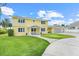 Bright yellow two-story home featuring a spacious lawn and attached two-car garage at 5224 Saint Regis Pl, Belle Isle, FL 32812