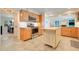 Well-lit kitchen features stainless appliances, wood cabinets, and a center island for food preparation at 5224 Saint Regis Pl, Belle Isle, FL 32812