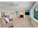 Inviting living room with a fireplace, built-in shelving, and large windows overlooking the outdoor space at 5224 Saint Regis Pl, Belle Isle, FL 32812