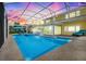 Beautiful pool with lake view, lanai with patio furniture, and gorgeous yellow house at 5224 Saint Regis Pl, Belle Isle, FL 32812