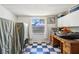 Finished basement showcasing black and white tile flooring, a wooden desk, and ample storage at 525 E Foothill Way, Casselberry, FL 32707