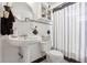 Charming bathroom featuring a classic pedestal sink, toilet, and striped shower curtain at 525 E Foothill Way, Casselberry, FL 32707