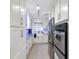 Galley kitchen features white cabinets, stainless steel appliances, and granite countertops at 525 E Foothill Way, Casselberry, FL 32707