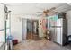 Enclosed patio with ceiling fan, sliding glass doors, and stainless steel refrigerator offers convenient indoor-outdoor living at 525 E Foothill Way, Casselberry, FL 32707