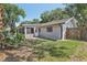 A fully fenced backyard with lush green lawn, a screened porch, and mature landscaping at 525 Legume Dr, Port Orange, FL 32127