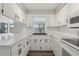 Bright kitchen featuring ample countertop space, white cabinetry, and a view to the outside at 525 Legume Dr, Port Orange, FL 32127