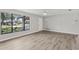 Living room with wood-look flooring, light colored walls, ceiling fan, and large windows at 525 Legume Dr, Port Orange, FL 32127