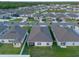 Aerial view of neighborhood and houses with a lake in background at 543 Pine Tree Bridge Trl, St Cloud, FL 34772