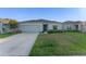 Attractive single-Gathering home featuring a two-car garage, a well-kept lawn, and a charming front entrance under a sunny sky at 543 Pine Tree Bridge Trl, St Cloud, FL 34772