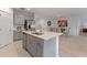 Modern kitchen featuring an island with a sink, stainless steel appliances, and gray cabinets at 543 Pine Tree Bridge Trl, St Cloud, FL 34772