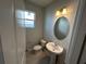 Powder room features a pedestal sink, tile floors, a window, and neutral wall color at 620 Pothos St, Apopka, FL 32703