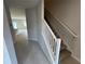 Hallway view into a home featuring tile floors and stairs with carpeted steps and white railing at 620 Pothos St, Apopka, FL 32703