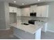 Bright kitchen featuring white cabinets, stainless steel appliances, kitchen island, and tile backsplash at 620 Pothos St, Apopka, FL 32703