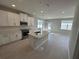 Open concept kitchen, featuring white cabinets, stainless steel appliances, kitchen island, and tile floors at 620 Pothos St, Apopka, FL 32703