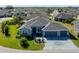 Expansive aerial shot of a single-story home with a three-car garage in a quiet neighborhood at 6328 Merhottein Loop, The Villages, FL 32163