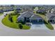 Gorgeous aerial view of a gray home with a wide driveway and 3 car garage at 6328 Merhottein Loop, The Villages, FL 32163