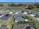Beautiful home with a well-manicured lawn, located near a pond with lush green trees, offering a serene and picturesque setting at 6328 Merhottein Loop, The Villages, FL 32163