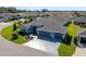 Aerial view of a beautiful single-story home, boasting a three-car garage and decorative concrete driveway at 6328 Merhottein Loop, The Villages, FL 32163