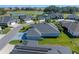 Aerial view showing a home with a well-kept lawn next to a neighborhood golf course at 6328 Merhottein Loop, The Villages, FL 32163