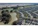 Expansive aerial view of the community, showcasing lush green golf courses, serene ponds, and beautifully landscaped homes at 6328 Merhottein Loop, The Villages, FL 32163