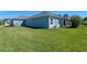 Expansive backyard with lush green grass, and neutral colored exterior of home at 6328 Merhottein Loop, The Villages, FL 32163