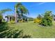 Lush backyard with manicured landscaping, mature trees, and solar panels; perfect for outdoor living and entertaining at 6328 Merhottein Loop, The Villages, FL 32163