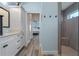 Bathroom showcasing white cabinetry, shower, toilet, and mirrors in a light blue interior at 6328 Merhottein Loop, The Villages, FL 32163