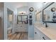 Bright bathroom with double vanity, modern fixtures, and decorative mirrors, and a separate toilet room at 6328 Merhottein Loop, The Villages, FL 32163