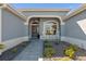 Inviting front entrance with decorative pavers, accent lighting, stylish door and charming rocking chairs at 6328 Merhottein Loop, The Villages, FL 32163