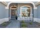 Cozy front entrance featuring a stylish door, decorative lighting, and charming rocking chairs for relaxing at 6328 Merhottein Loop, The Villages, FL 32163