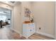 Hallway featuring stylish flooring, a white cabinet with decor, and a view into the bedroom at 6328 Merhottein Loop, The Villages, FL 32163