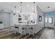 Bright kitchen boasts white cabinets, granite counters, pendant lighting and barstool seating at peninsula at 6328 Merhottein Loop, The Villages, FL 32163