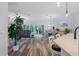 Open-concept living and dining area with wood-look floors and sliding glass doors to the outdoor space at 6328 Merhottein Loop, The Villages, FL 32163